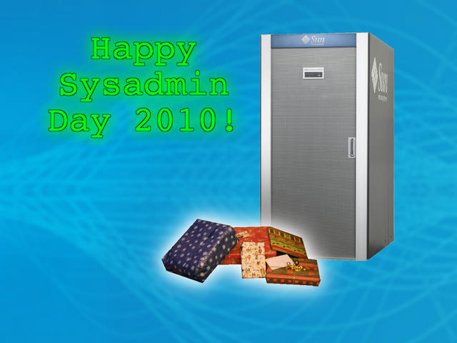 Green glowing “Happy Sysadmin Day 2010!” text beside a large Sun Microsystems server rack with wrapped gift boxes at its base.